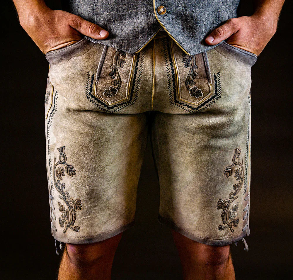 Eine moderne beige Lederhose für Herren von Datschi Trachten mit detailreichen, hellen Stickereien